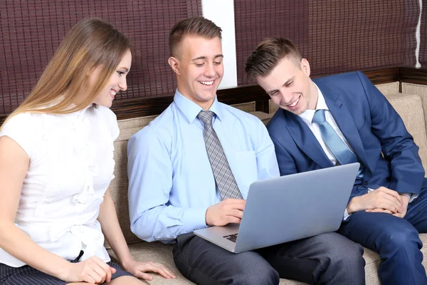 Young business people sitting on couch in office