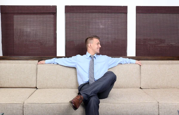 Giovane uomo d'affari che riposa sul divano in ufficio — Foto Stock