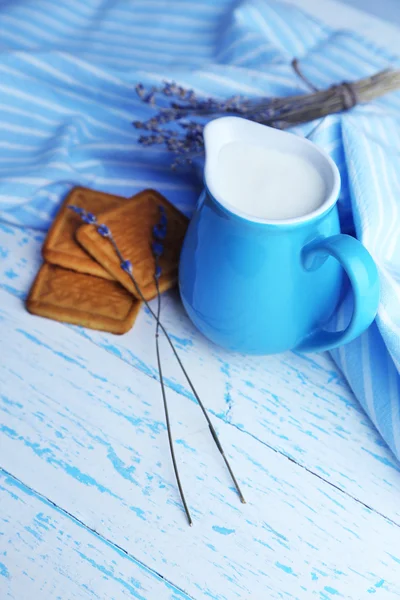 Yogur casero en jarra y sabrosa galleta sobre fondo de mesa de madera — Foto de Stock