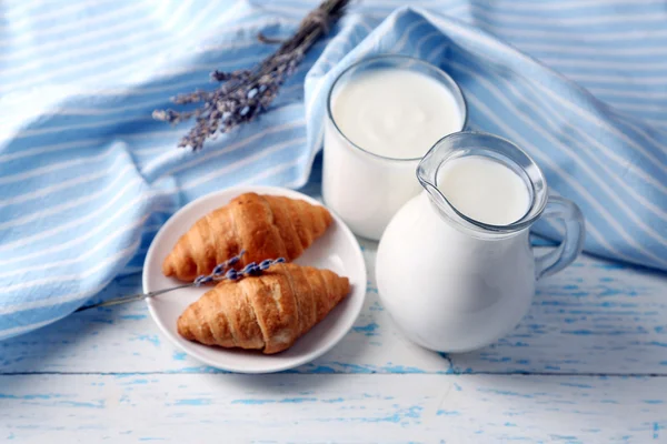 Yogur casero en jarra y sabrosos croissants sobre fondo de mesa de madera —  Fotos de Stock