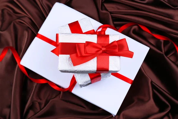 Bellissimi regali con nastri rossi su sfondo di seta — Foto Stock