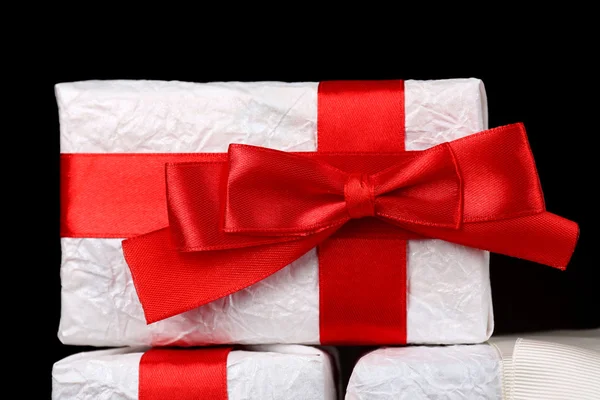 Beautiful gifts with red ribbons on dark background — Stock Photo, Image