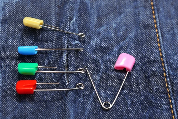 Safety pins on fabric background — Stock Photo, Image