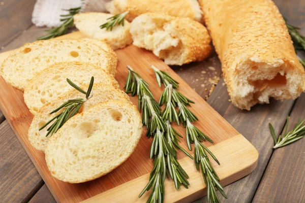 Pan fresco con aceite de oliva y romero sobre mesa de madera —  Fotos de Stock