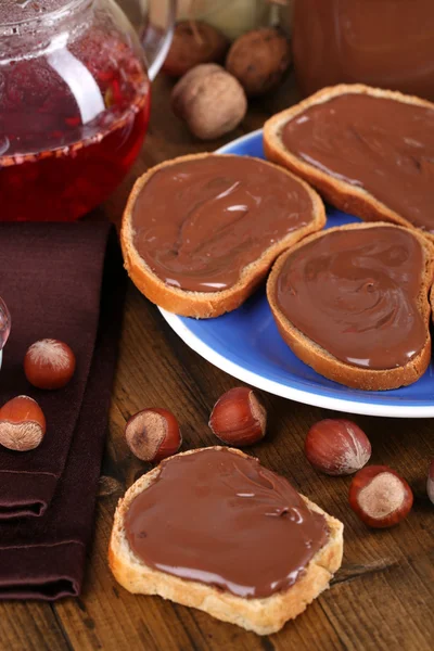 Brot mit süßem Schokoladen-Haselnussaufstrich auf Teller auf Tisch — Stockfoto