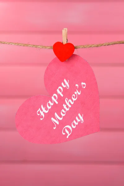 Feliz Dia das Mães mensagem escrita em papel coração sobre fundo rosa — Fotografia de Stock
