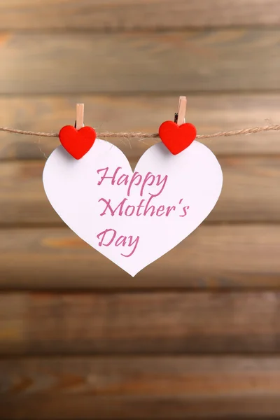 Wiadomość dzień matki Happy napisany na papierze serca na brązowym tle — Zdjęcie stockowe