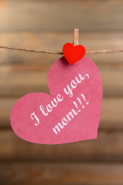 Gelukkig moeders dag bericht geschreven op papier hart op bruine achtergrond — Stockfoto