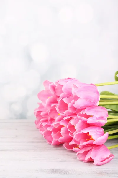 Lindas tulipas cor-de-rosa na mesa de madeira — Fotografia de Stock