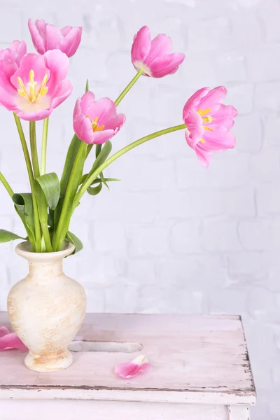 Schöne rosa Tulpen auf grauem Wandhintergrund — Stockfoto