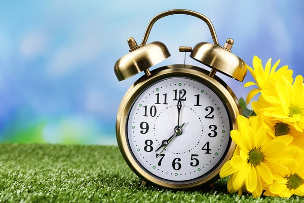 Alarm clock on green grass, on nature background — Stock Photo, Image