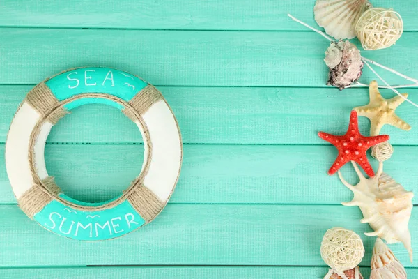 Lifebuoy and sea shells on wooden background — Stockfoto