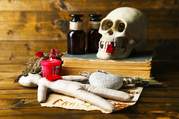 Conceptual photo of love magic. Composition with skull, voodoo doll, dried herbs and candle on  dark wooden background — Stock Photo, Image