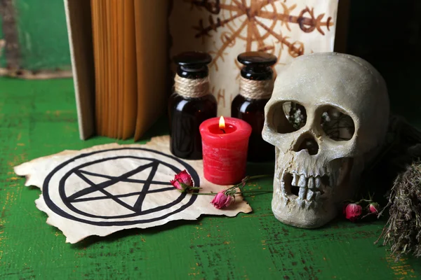 Composition with skull,old book, magic potions, candle and dry herbs  on color wooden background — Stock Photo, Image