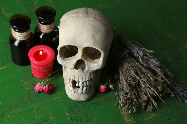 Composition avec crâne, et, potions magiques, bougie sur fond en bois de couleur — Photo