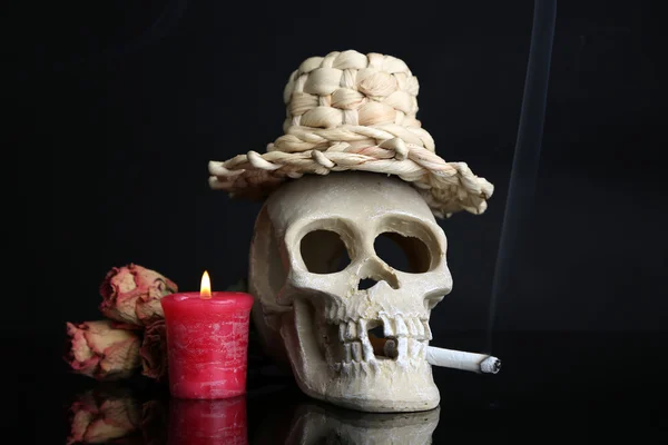 Composición con cráneo en sombrero, vela y rosa seca aislada sobre negro — Foto de Stock