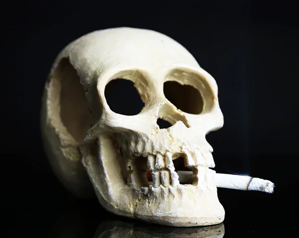 Skalle med cigarett isolerade på svart — Stockfoto