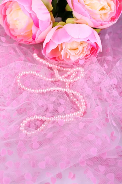 Beautiful pearls on pink cloth — Stock Photo, Image