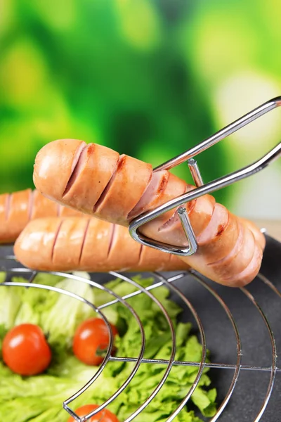 Grilled sausage in wok on bright background — Stock Photo, Image