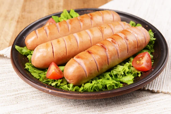 Grilled sausage on plate on table close-up — Stock Photo, Image