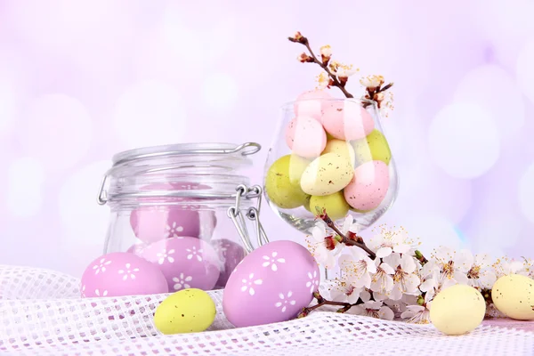 Composition with Easter eggs and blooming branches on light background — Stock Photo, Image