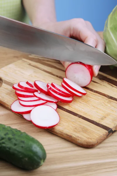 Female hands cutting celery on wooden board, close-up, on blue background — Stock Photo, Image