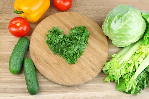 A forma di cuore di erbe tagliate e verdure fresche, su sfondo di legno — Foto Stock