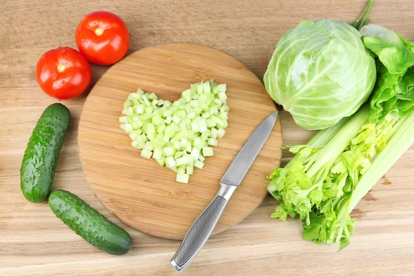 心的剁碎的芹菜和新鲜的蔬菜，木制的背景上的形状 — 图库照片