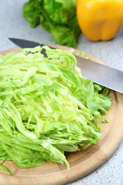 Chopped cabbage on wooden board, close-up, on kitchen table background — Stock Photo, Image