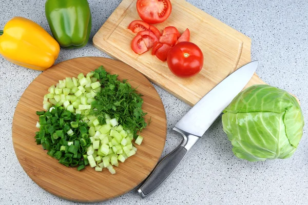 Composición con hierbas picadas sobre tabla de madera y verduras frescas, sobre fondo de mesa de cocina — Foto de Stock