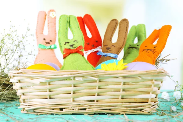 Grappige handgemaakte Pasen konijnen in rieten mand — Stockfoto