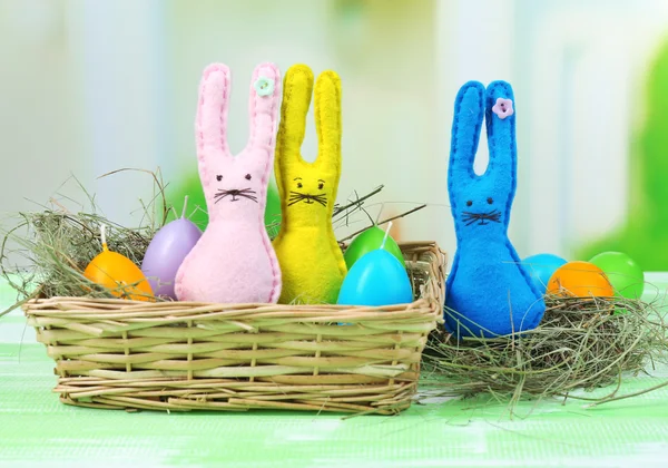 Divertidos conejos de Pascua hechos a mano en canasta de mimbre —  Fotos de Stock