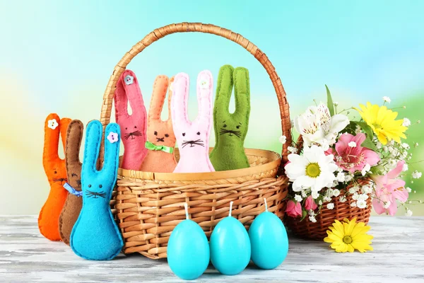 Composition with funny handmade Easter rabbits in wicker basket — Stock Photo, Image