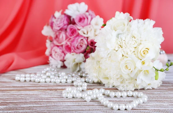 Красивые свадебные букеты на столе на фоне ткани — стоковое фото