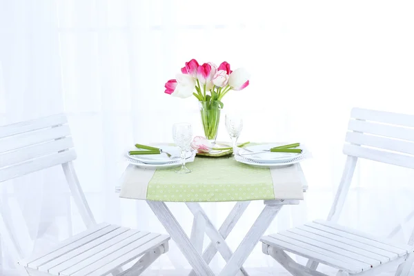 Nya bord och stolar med plats inställningar på ljus bakgrund — Stockfoto