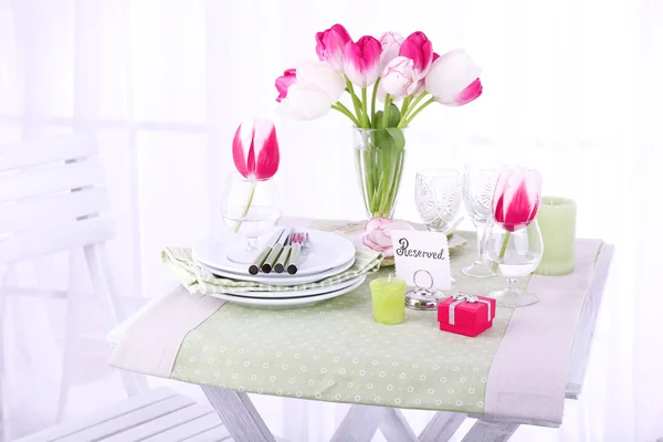 New table and chairs with place settings on light background — Stock Photo, Image