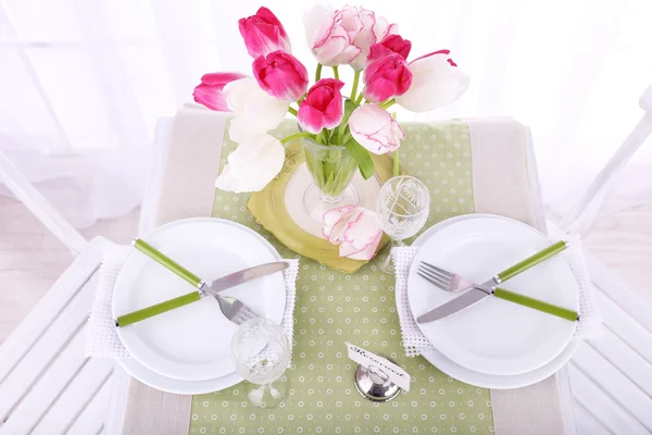 New table and chairs with place settings on light background — Stock Photo, Image