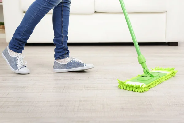 Woman with mop cleaning wooden floor from dust — Stock Photo, Image