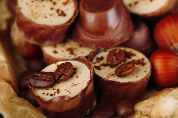 Lekkere chocolade snoepjes met koffiebonen en noten, close-up — Stockfoto