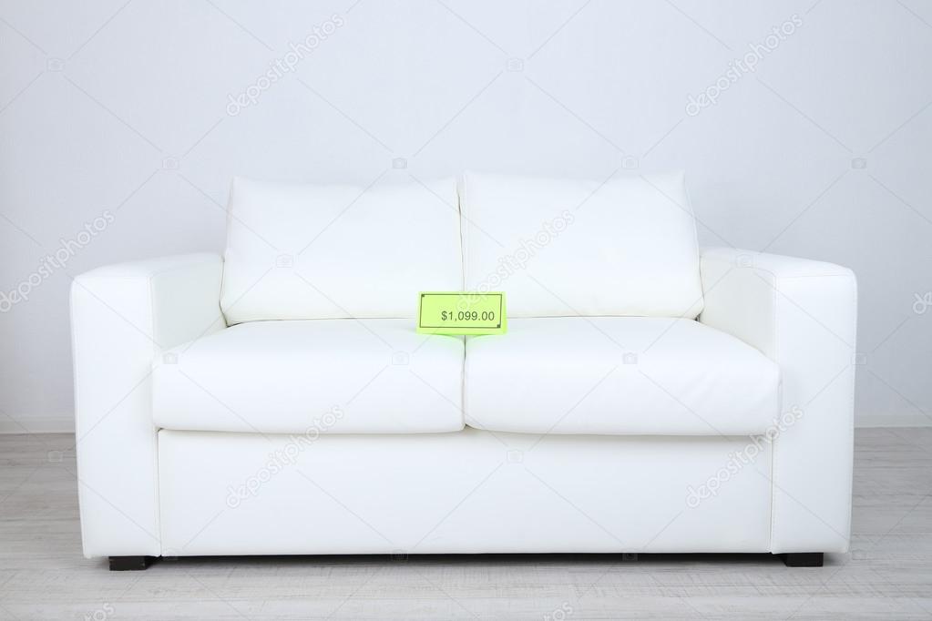 New white sofa with price on light background