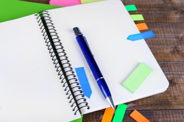 defter, kalem ve ahşap zemin üzerinde çıkartmalar