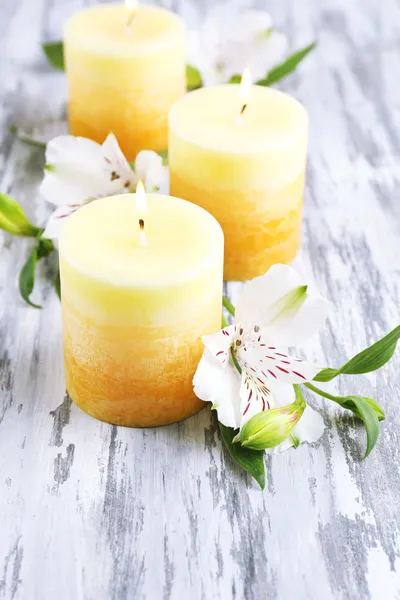 Красивые свечи с цветами на фоне дерева — стоковое фото