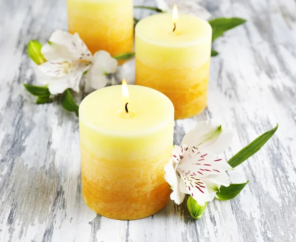 Belas velas com flores no fundo de madeira — Fotografia de Stock