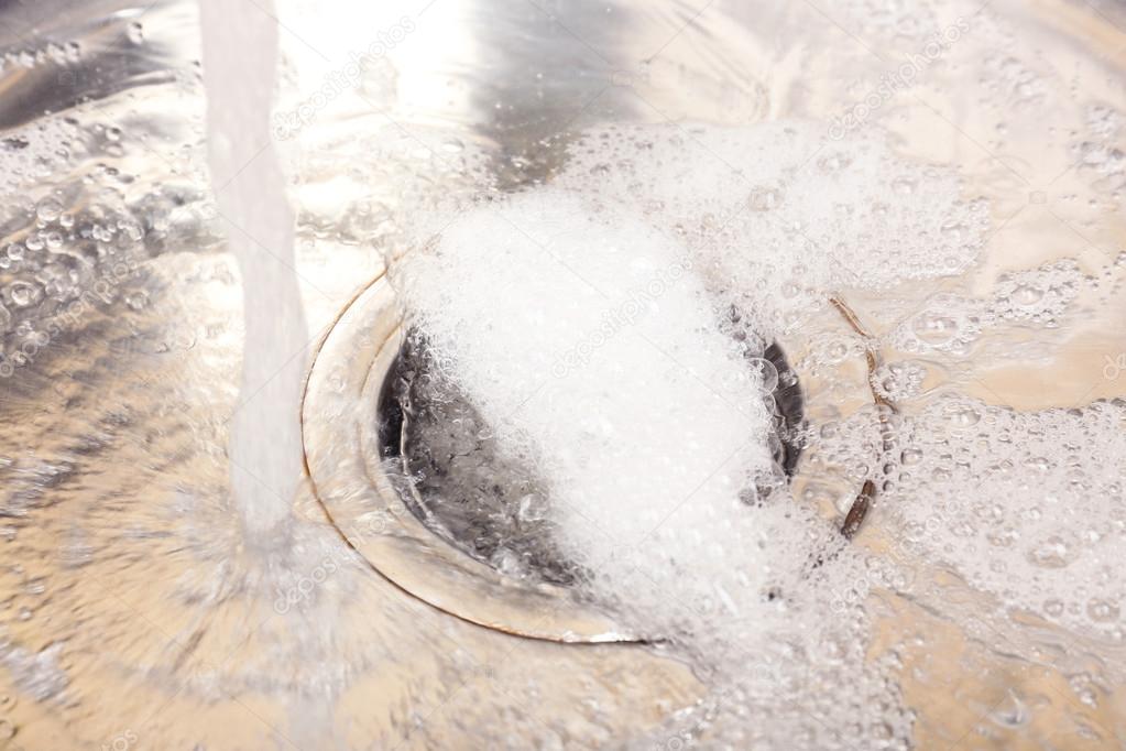 Water flowing down hole in kitchen sink