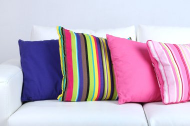 Beyaz kanepe ile oda içinde renkli yastıklar 