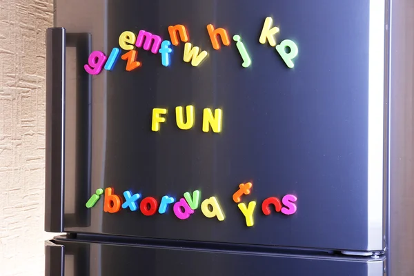 Palavra Diversão soletrado usando letras magnéticas coloridas na geladeira — Fotografia de Stock