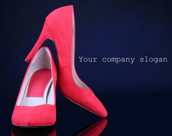 Vackra röda kvinnligt skor, på blå bakgrund — Stockfoto