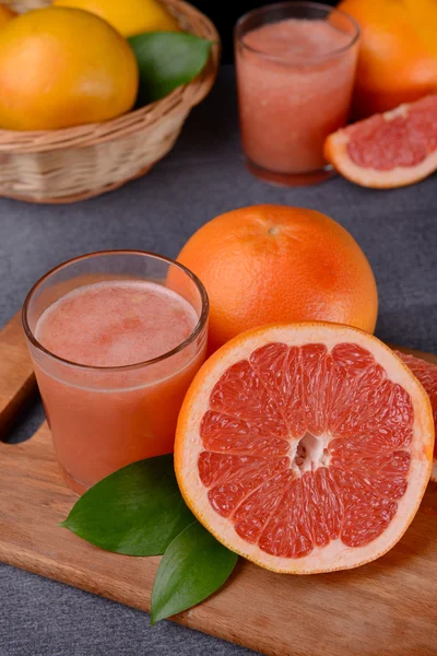 Спелый грейпфрут с соком на столе крупным планом — стоковое фото