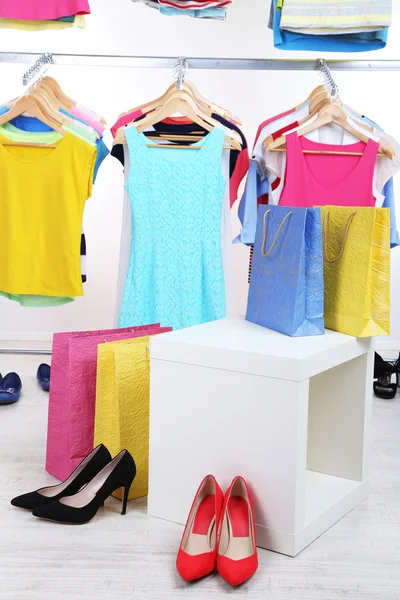 Různé oblečení na ramínkách a boty na světlé pozadí — Stock fotografie