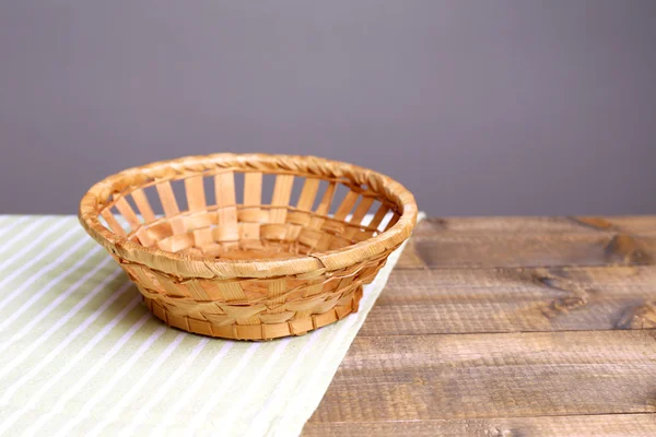 Cesta de mimbre vacía sobre mesa de madera, sobre fondo oscuro —  Fotos de Stock